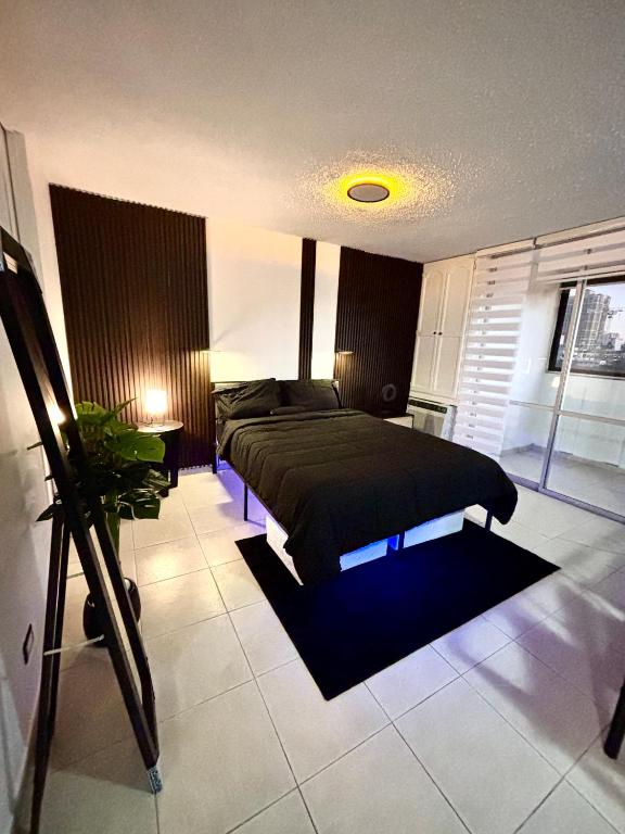 a bedroom with a bed with a black blanket at Son de Metro Apartment - Condado Beach & Pool, Walk to Ocean in San Juan