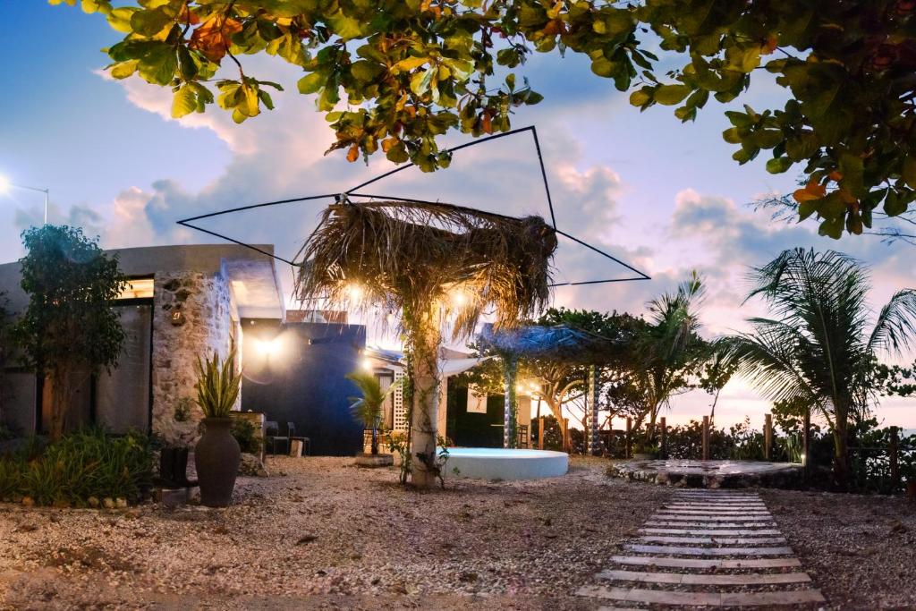a house with a palm tree in front of it at Habitación, balcón frente al mar y alberca in Lerma