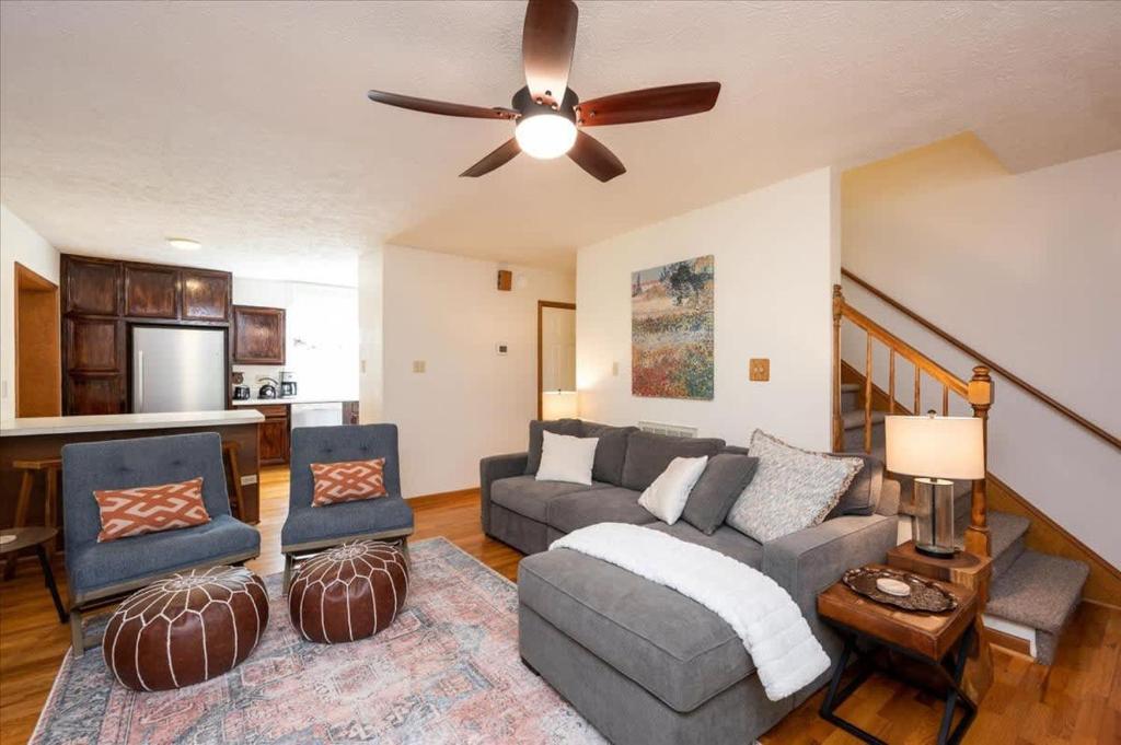een woonkamer met een bank en een plafondventilator bij Quiet Retreat - Piano Firepit Peloton in Pittsboro