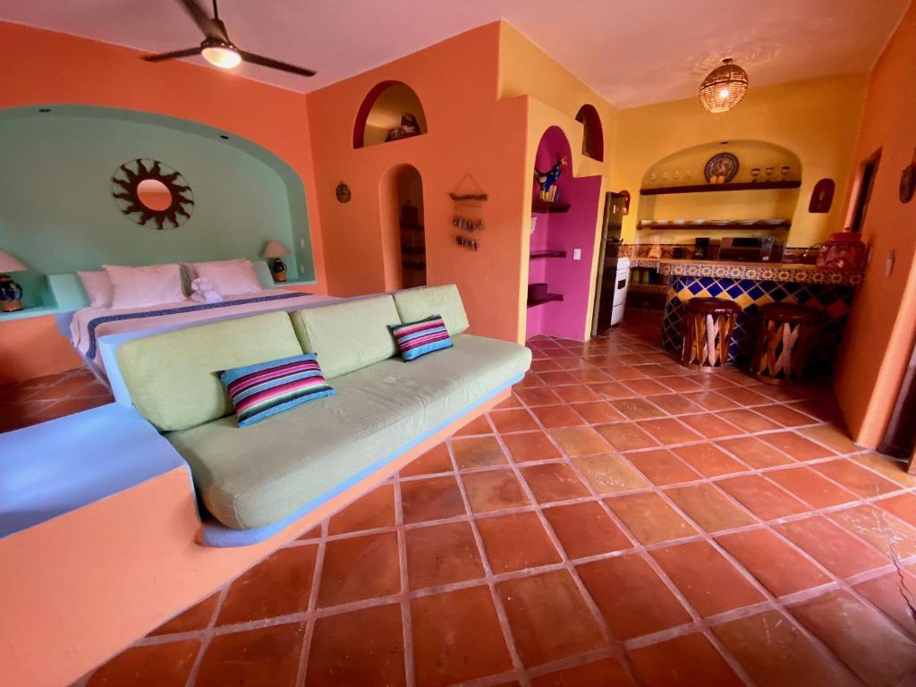 a living room with a couch in the middle at Sol - Casa MoJo's charming 1BR, kitchen, pool in Sayulita