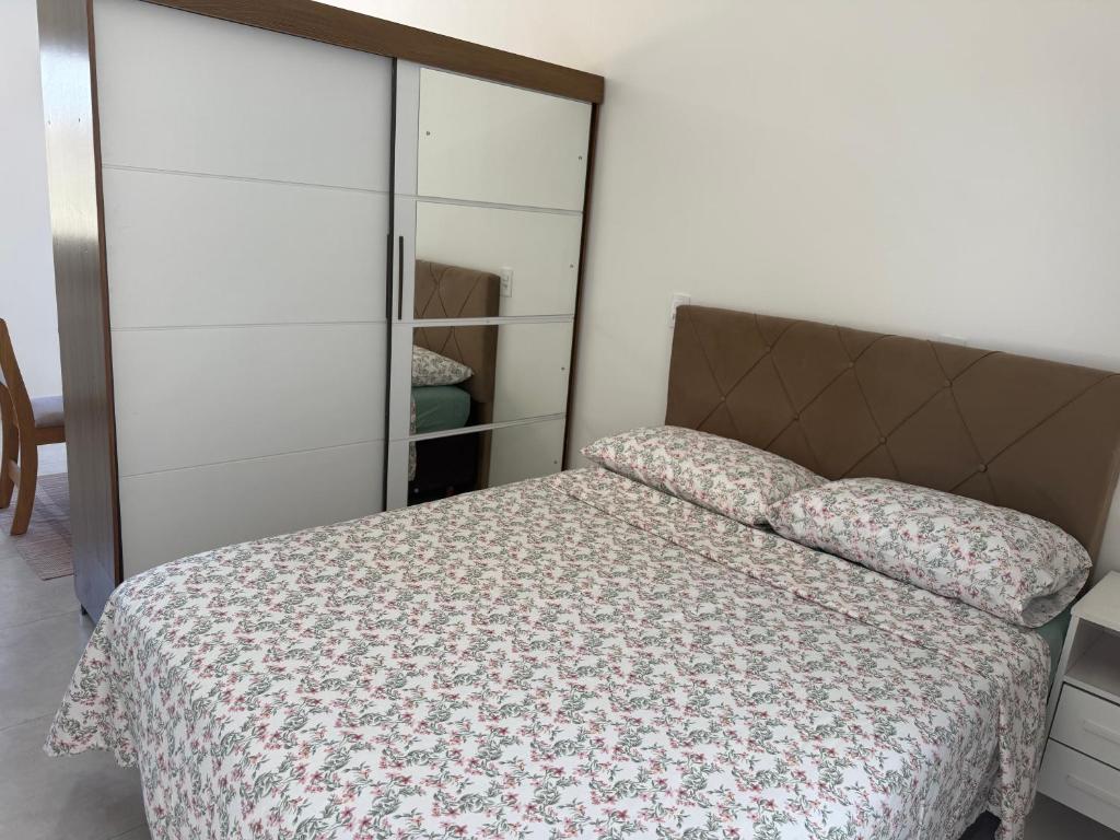 een slaapkamer met een bed en een kast bij Loft novo e bem localizado in Biguaçu