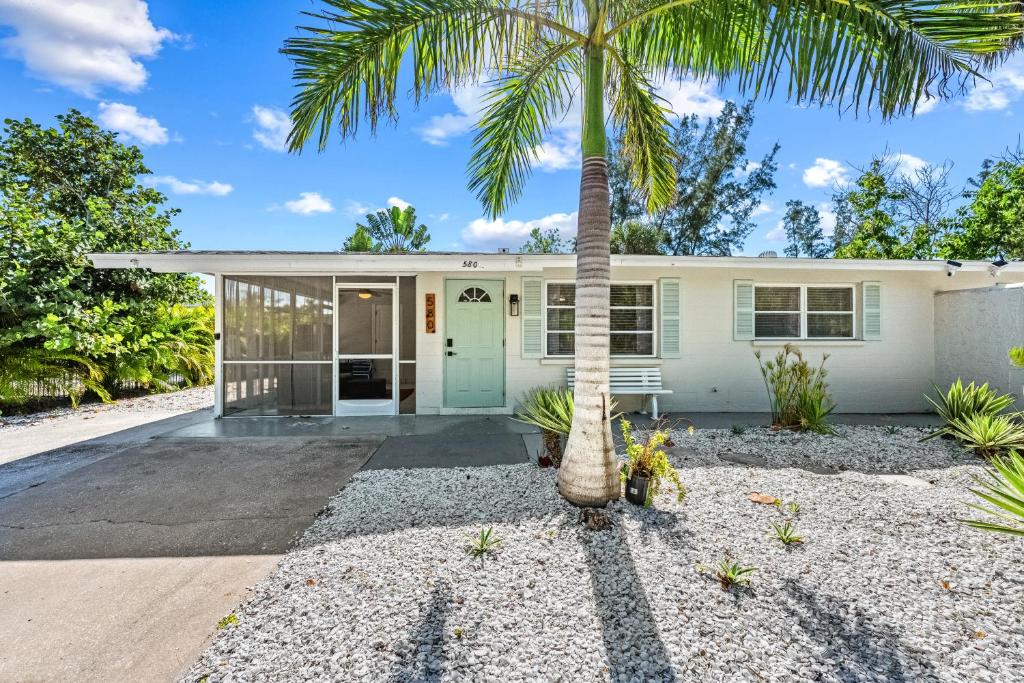 a palm tree in front of a house at Starfish Sands - 580 in Longboat Key