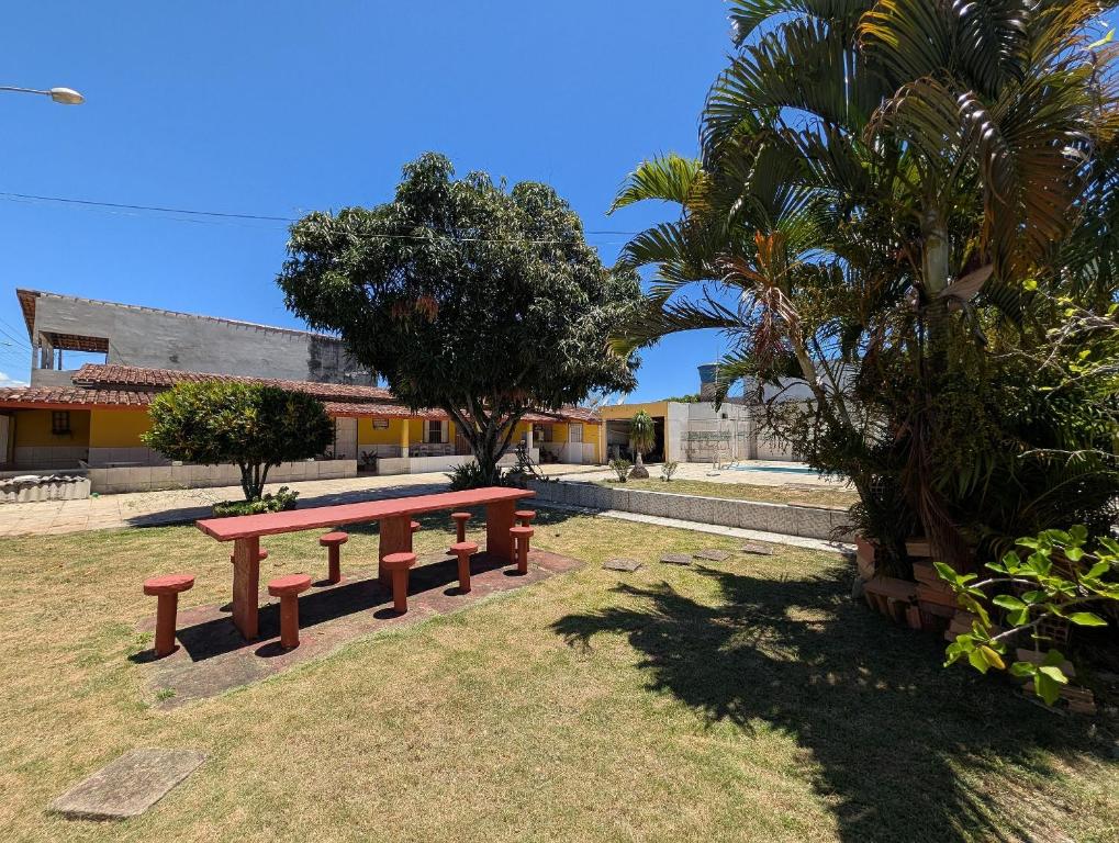 una panchina da picnic in un parco con palme di Casa Temporada Refúgio das Ondas a Guriri
