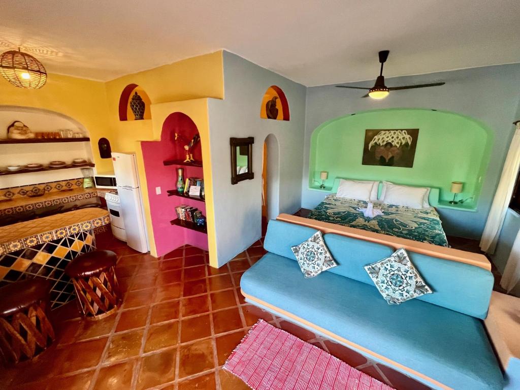 a bedroom with a blue bed in a room with colorful walls at Luna - Casa MoJo's delightful 1BR, kitchen, pool in Sayulita