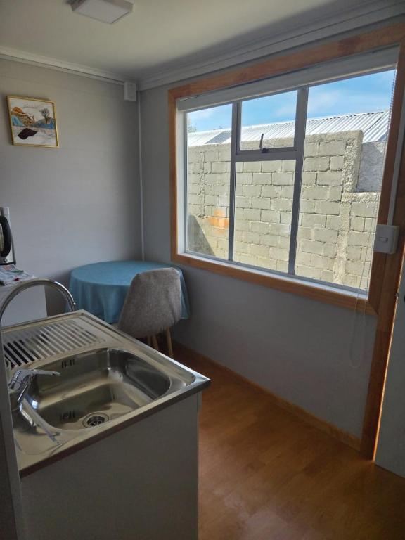 een keuken met een spoelbak en een raam bij Cabaña Full Equipada Sector Norte B2 