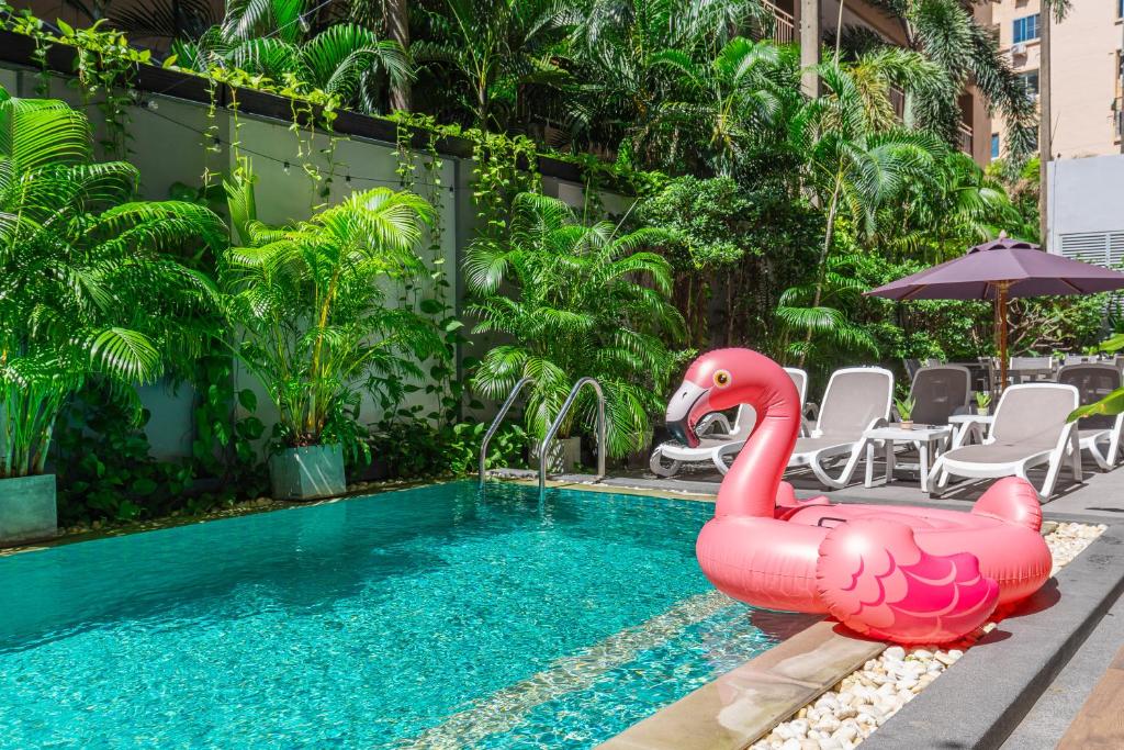 ein großer rosa aufblasbarer Schwan in einem Schwimmbecken in der Unterkunft WOOVO Phuket Patong - by Swandor in Patong Beach