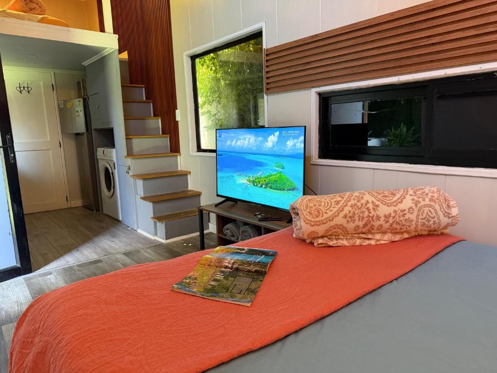a bedroom with a bed with a flat screen tv at Casa Panal , Jacuzzi opcional Villa Alemana in Villa Alemana