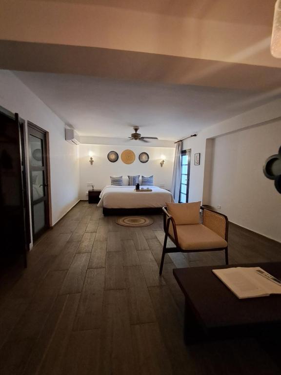 een hotelkamer met een bed en een stoel bij Hotel Boutique Patio Corao in Cartagena