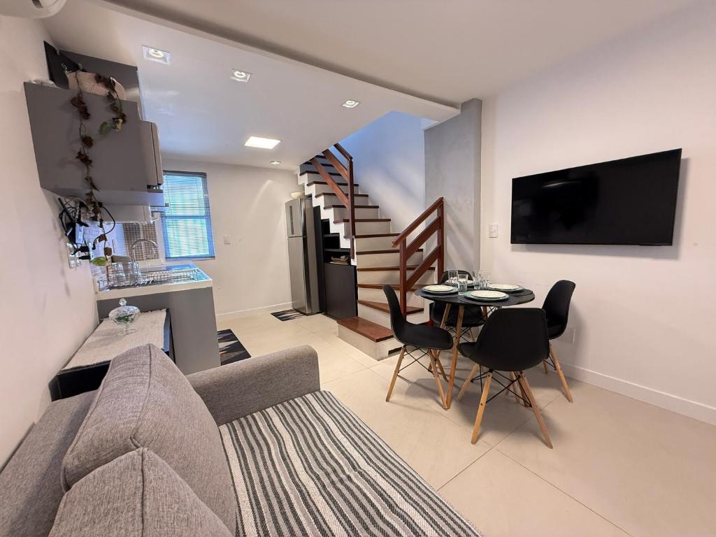 a living room with a couch and a table at Triplex Luxo 2 Qtos c Churrasqueira na Rua das Pedras in Búzios
