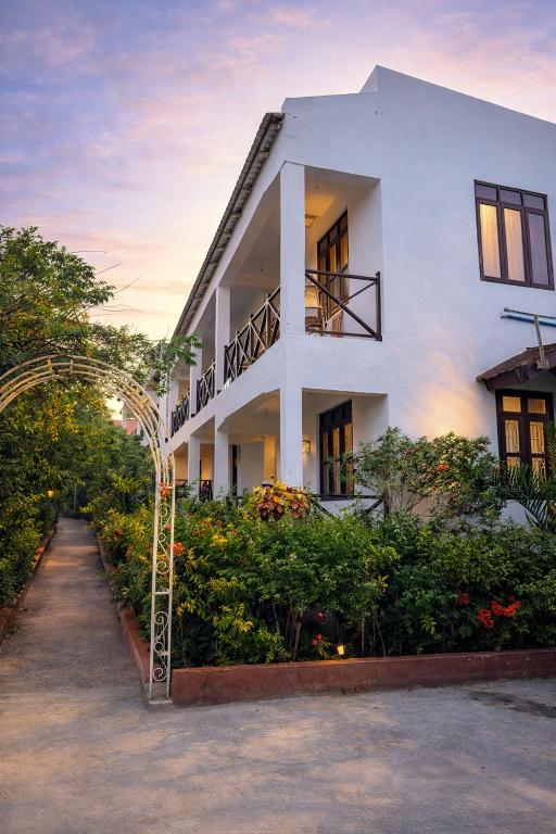 a white building with an arch in front of it at Majani Breeze Zanzibar in Nungwi