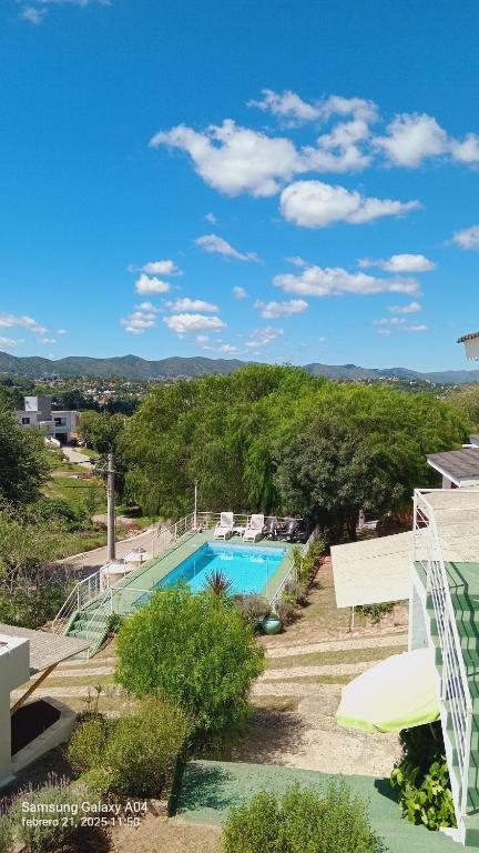 uitzicht op een zwembad in een tuin bij Cabañas Casitas De Emma in Villa Carlos Paz