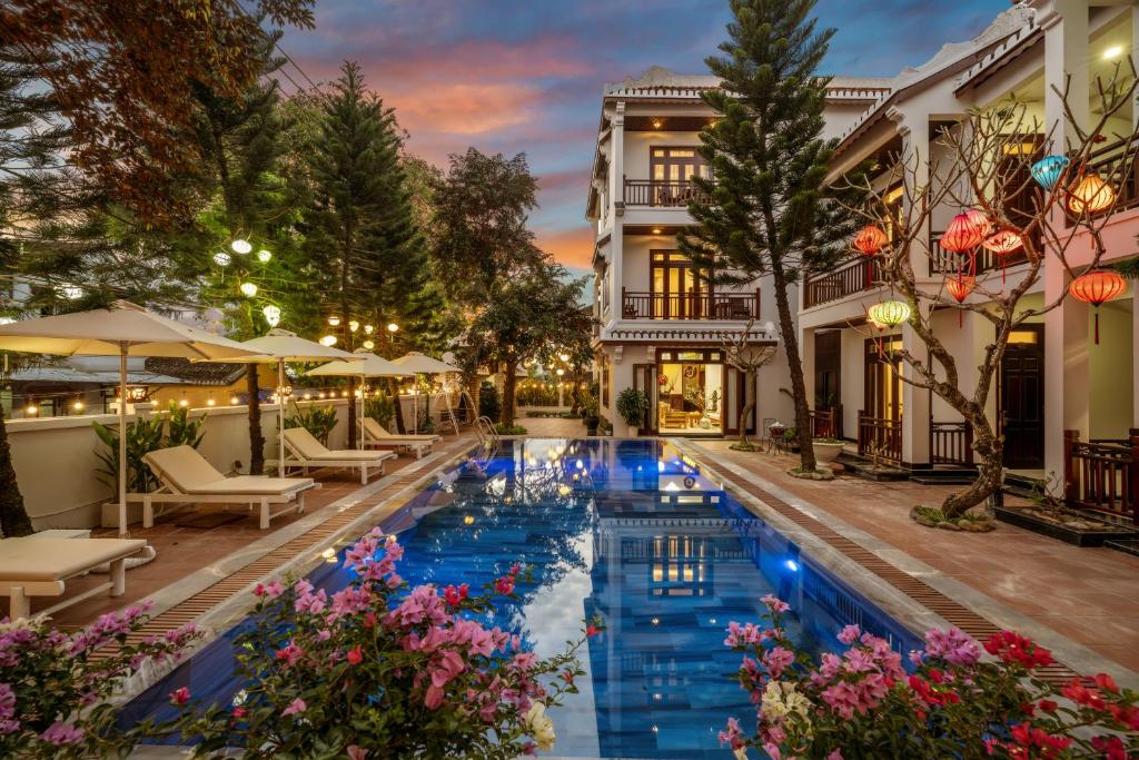 een zwembad in het midden van een gebouw met bloemen bij Paradise Boutique Hoi An in Hội An