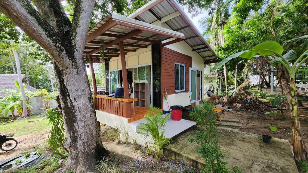 a small house with a porch and a tree at Casa Srithanu in Koh Phangan
