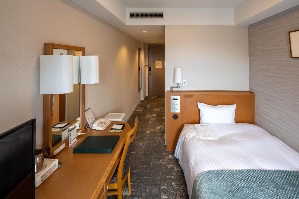 a hotel room with a bed and a desk at Toshi Center Hotel in Tokyo