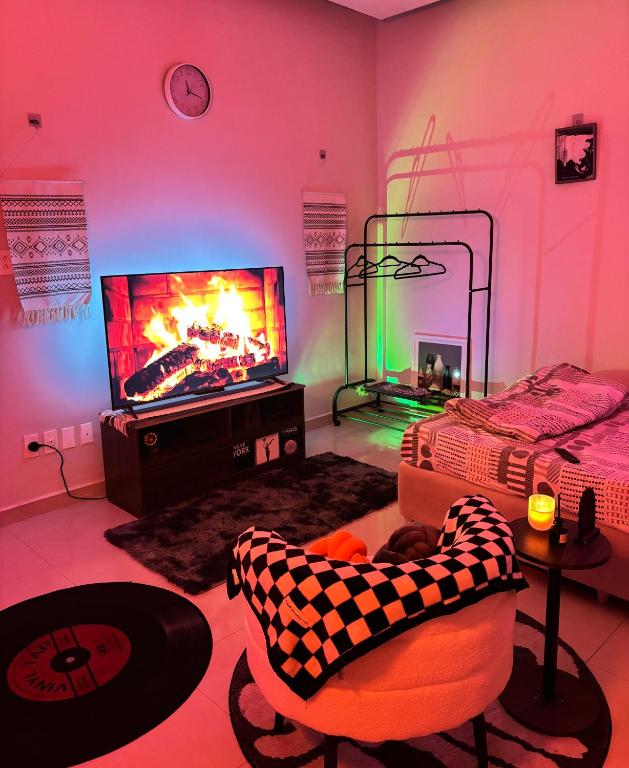 a living room with a tv and a couch and a chair at استوديو مميز بأثاث مريح in Al Khobar