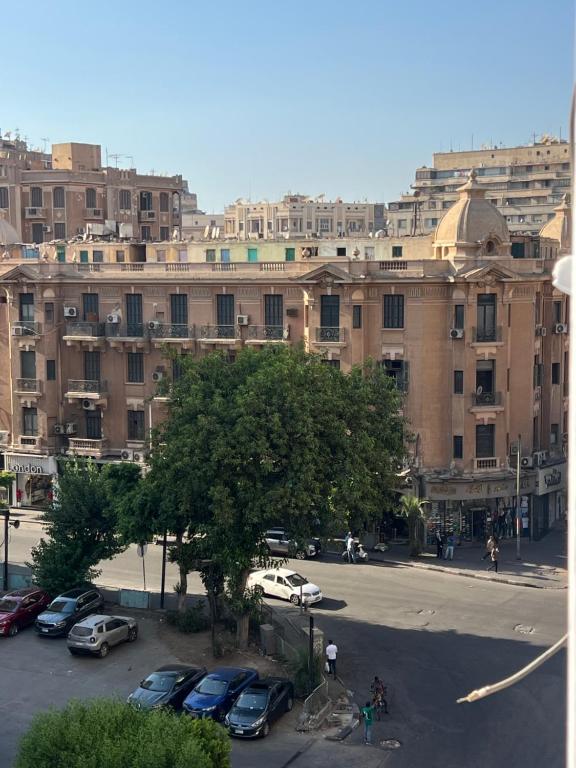 a large building with cars parked in a parking lot at Cozy apartment in down town in Cairo