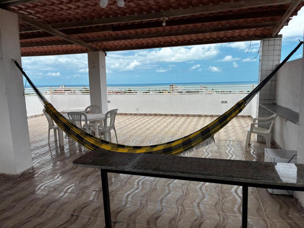 eine Hängematte auf einer Terrasse mit Blick auf den Strand in der Unterkunft Apartamento Duplex em Jacumã in Conde