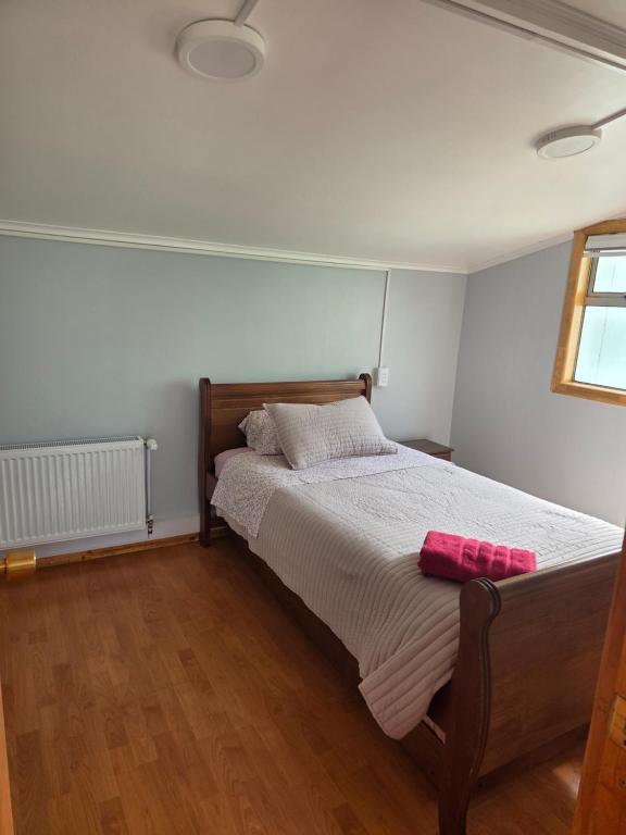 a bedroom with a bed with a pink towel on it at Cabaña full A1 in Punta Arenas