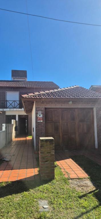 a brick house with a garage and a driveway at Duplex Playa in Santa Clara del Mar