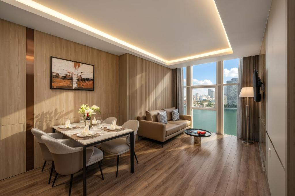 un soggiorno con tavolo, sedie e divano di Sun River Hotel a Da Nang