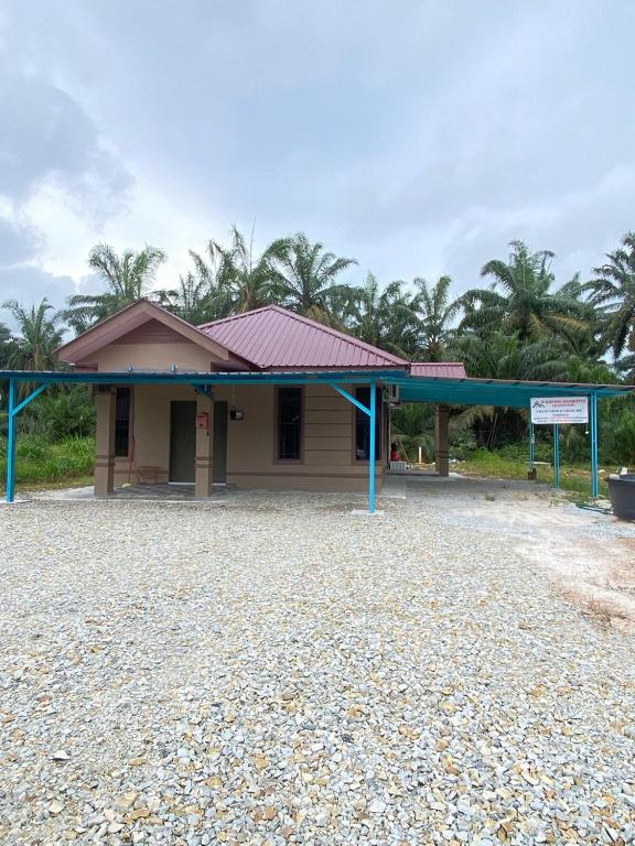 un piccolo edificio con un tetto blu su una strada sterrata di D'Kuning Homestay a Gua Sai