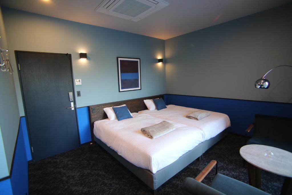 a bedroom with a large bed with two pillows on it at TAP Inn MIURA in Miura