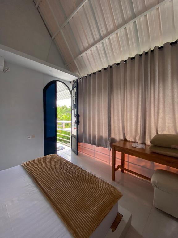 una camera da letto con un letto, un tavolo e una finestra di abneina pro homestay a Brassan