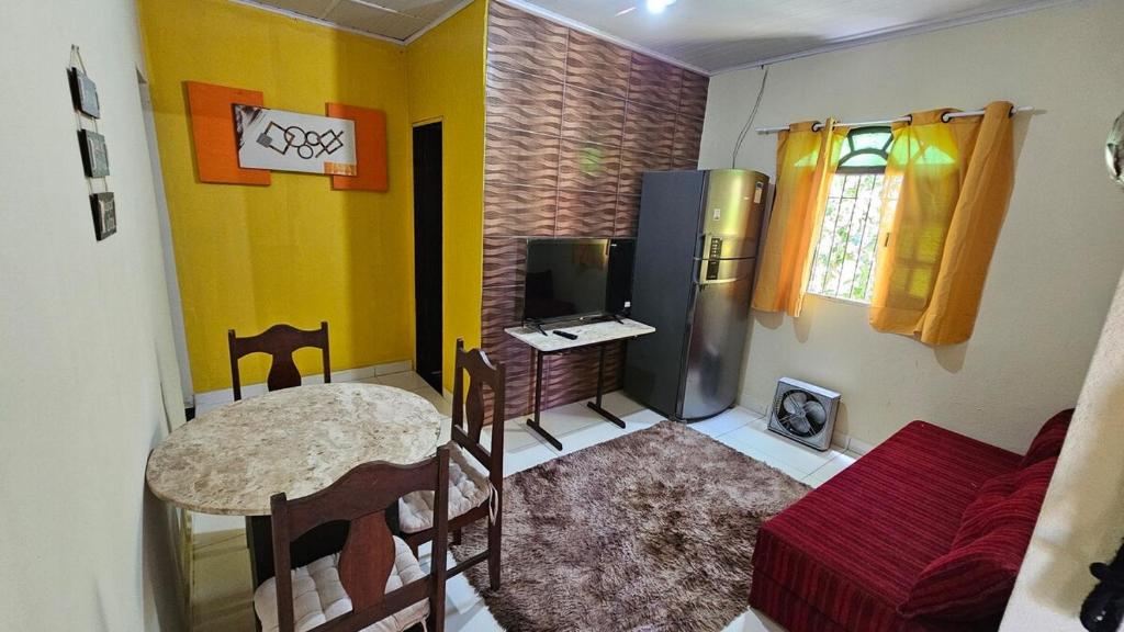 a small kitchen with a table and a refrigerator at Atlantic Residence - Guaxindiba in São Francisco de Itabapoana