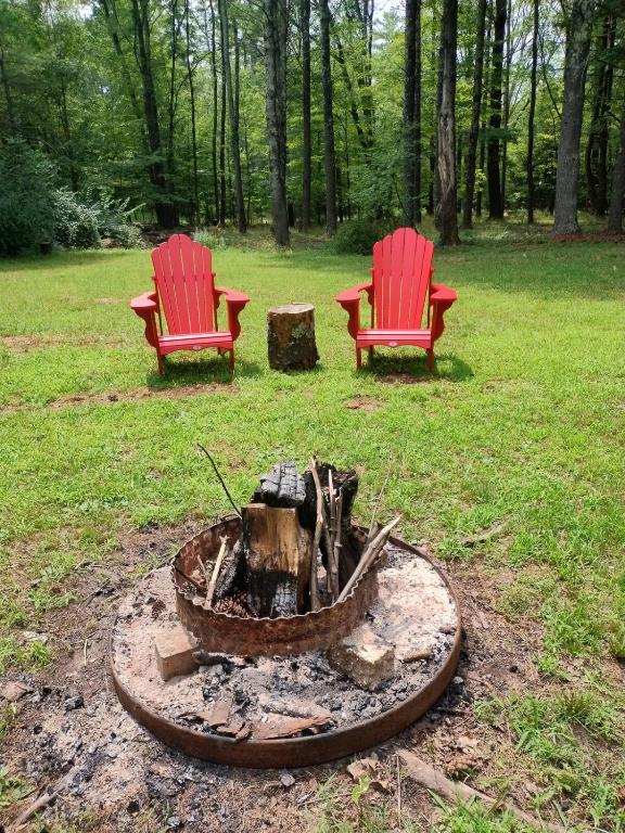 two red chairs sitting next to a fire pit at The Acorn at Oak Lodge in Palenville