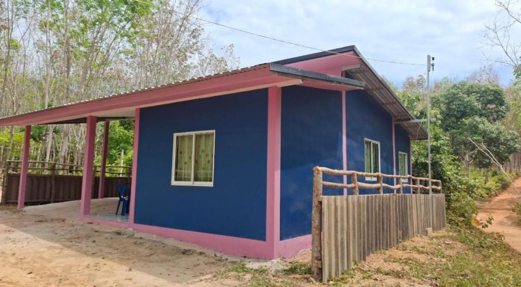 a small blue and pink house with a fence at Nasin House in Ko Bu Bu
