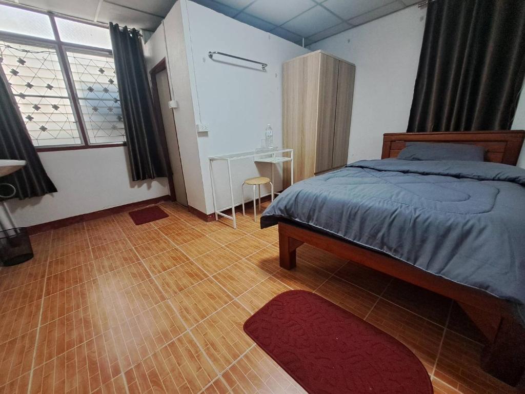 een slaapkamer met een bed en een houten vloer bij Casa Scarlet in Bangkok