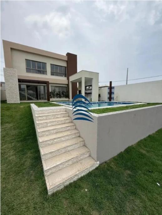 een gebouw met een trap die naar een zwembad leidt bij Casa in Lauro de Freitas