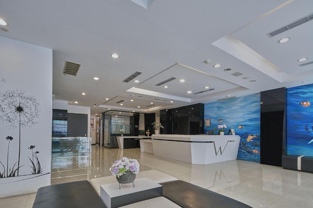 a lobby with a reception desk in a building at Wecan Hotel in Kaohsiung