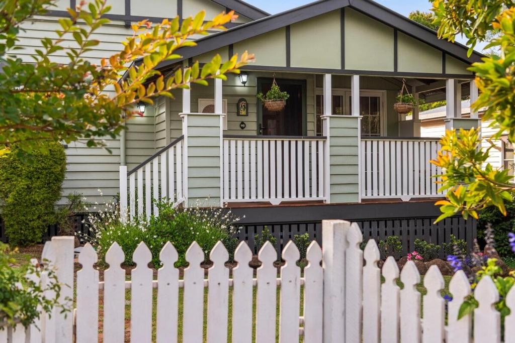 a white picket fence in front of a house at Clark Cottage in Toowoomba