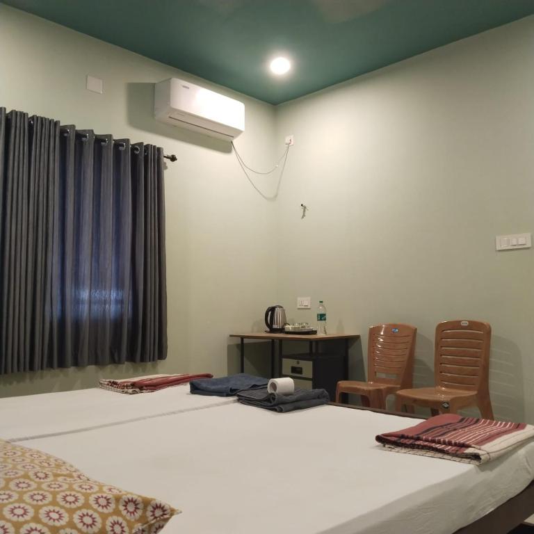 a bedroom with a bed and a desk and chairs at Cherish homestay in Cochin
