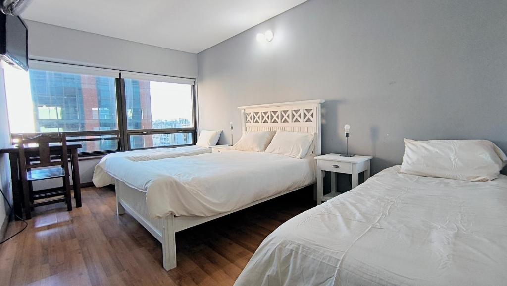 a bedroom with two beds and a large window at Amazing View Studio Obelisco in La Porteña