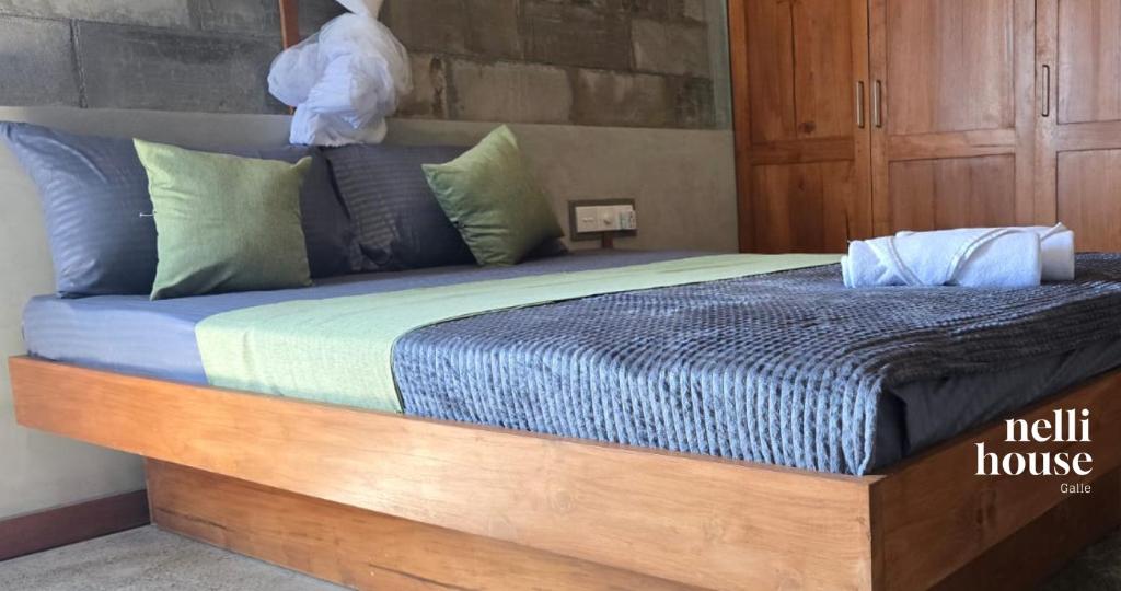 een groot bed met een houten frame in een slaapkamer bij nelli house in Galle