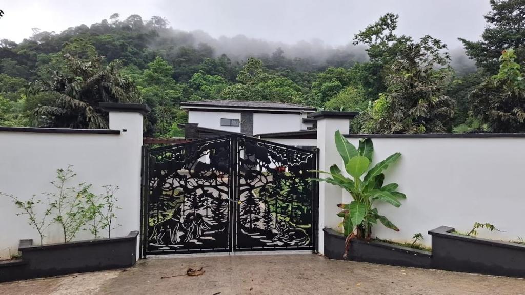 a gate to a house with a mountain in the background at Residential Finca Celeste in Bijagua