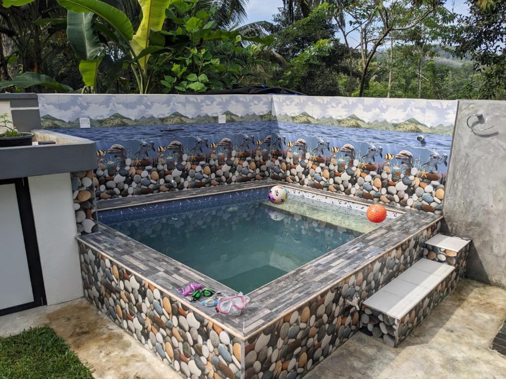 a pool with a rock retaining wall and a poolificialificialificialificialificialificial at SR Home stay in Matugama