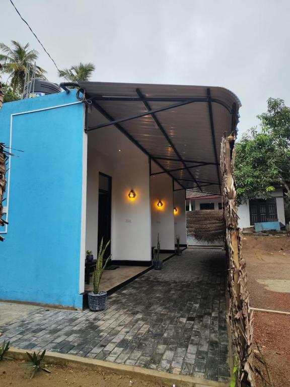 a blue and white building with a roof at Relax Corner in Hiriketiya