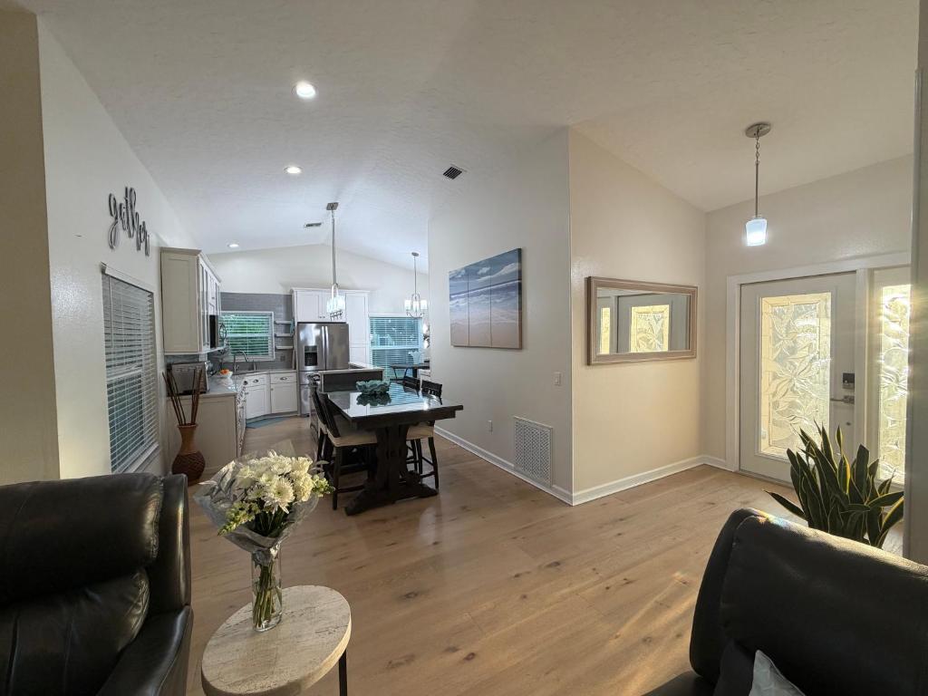 a living room with a table and a kitchen at Near KSC - Peaceful Spacious Home for 6 - Fully Stocked Kitchen and Coffee Bar in Titusville