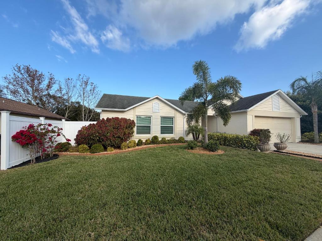 een huis met een groen gazon ervoor bij Coastal Launch Properties in Titusville