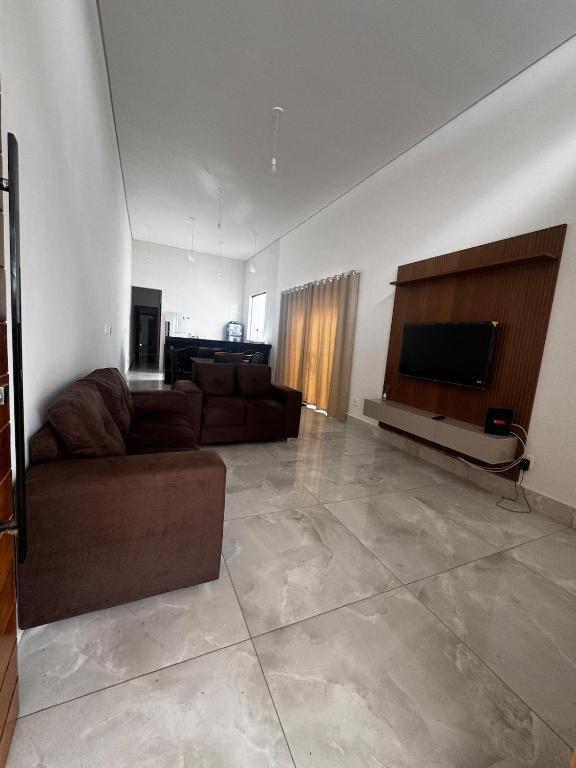 un salon avec un canapé et une télévision à écran plat dans l'établissement Casa alegre, à Belo Horizonte