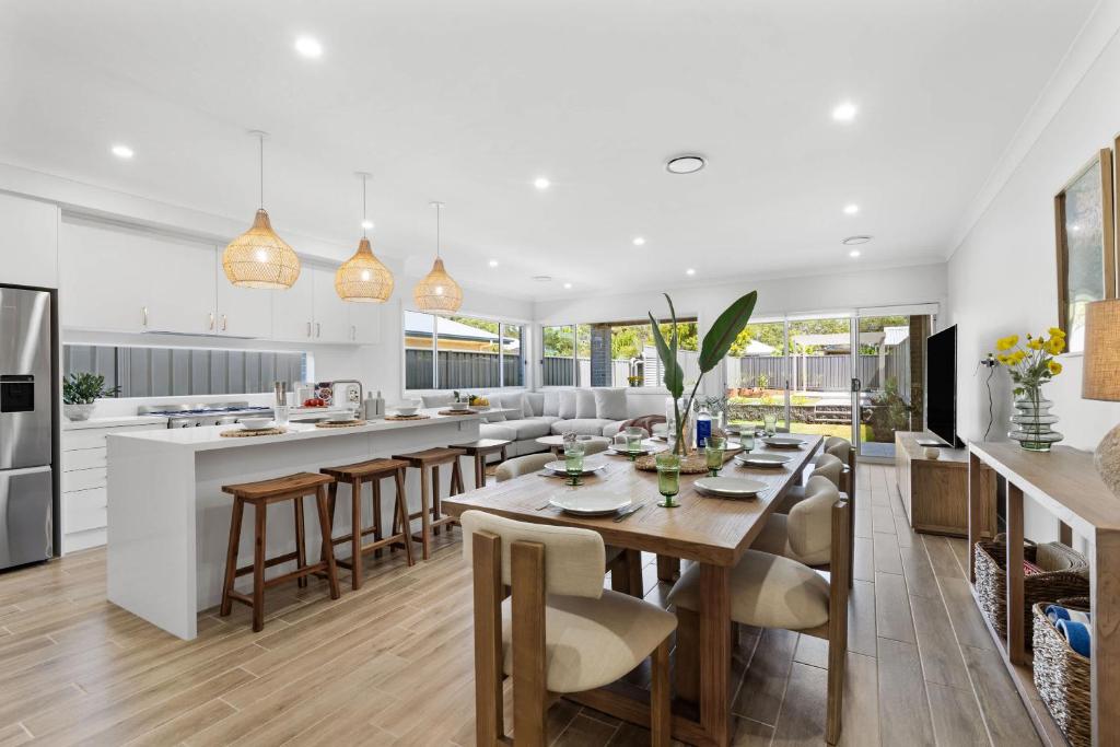 eine offene Küche und ein Esszimmer mit Tisch und Stühlen in der Unterkunft Mare Mio Callala Beach Jervis Bay in Callala Beach