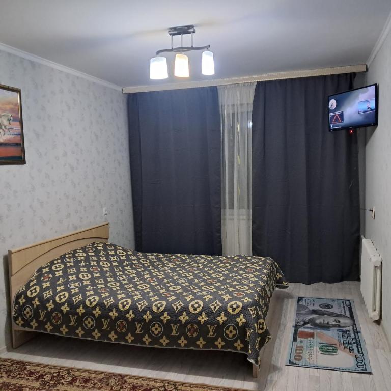 a bedroom with a bed and a television in it at 1 комн квартира рн Сазда БЦ МИР в Центре in Aktobe