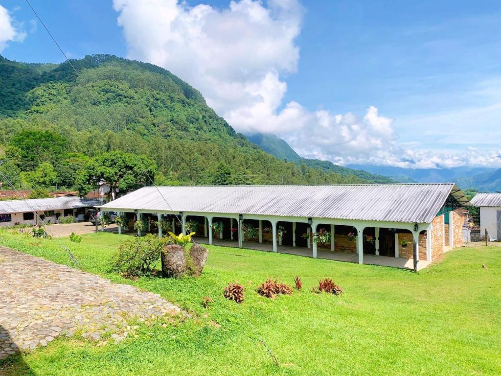 un bâtiment dans un champ avec une montagne en arrière-plan dans l'établissement Finca Hotel El Juncal, à Venecia