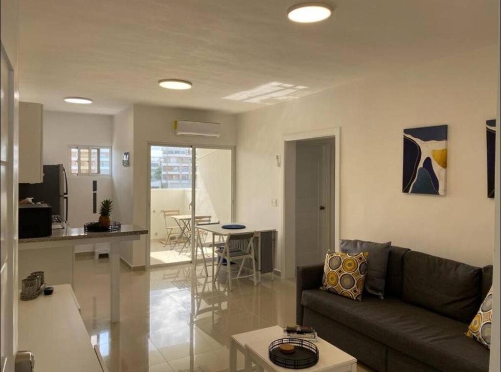 un soggiorno e una cucina con un divano e un tavolo di Fully furnished 2 bedroom appart a Bayahibe