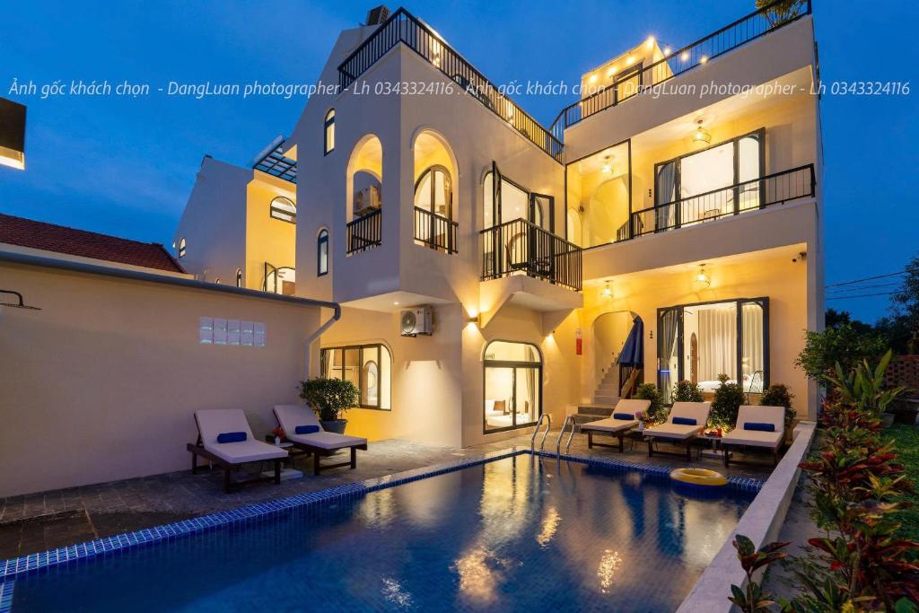 a villa with a swimming pool in front of a house at SEAESTA An Bang in An Bàn (2)
