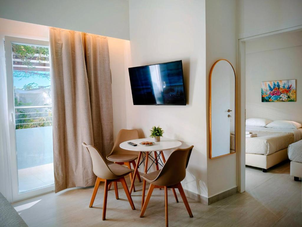 a living room with a table and chairs and a bed at Eva Ivoni apartments in Amoudara Herakliou