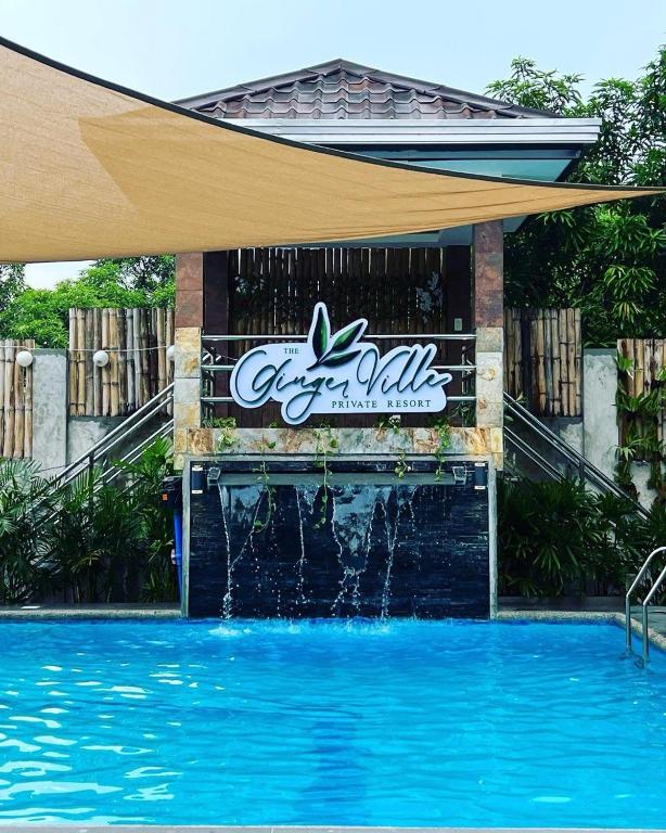 a swimming pool with a water fountain in front of a building at The Ginger Ville Private Resort in Lian